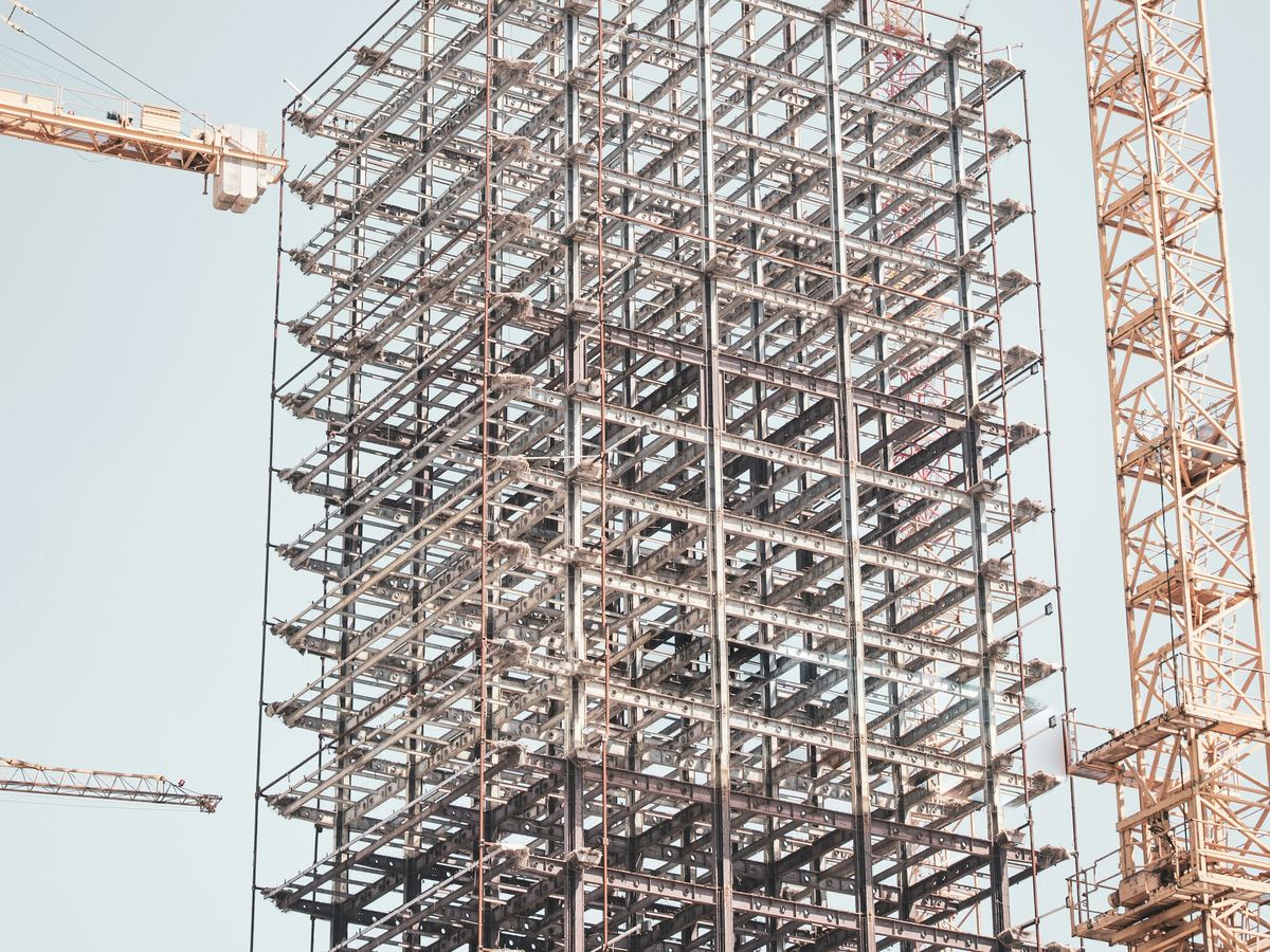 Structural steel frame of a commercial building beside a tower crane