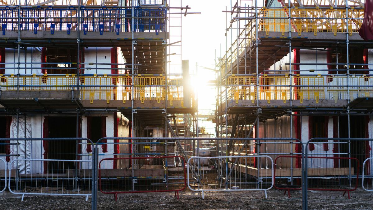 Two multi-story buildings wrapped in scaffolding during construction