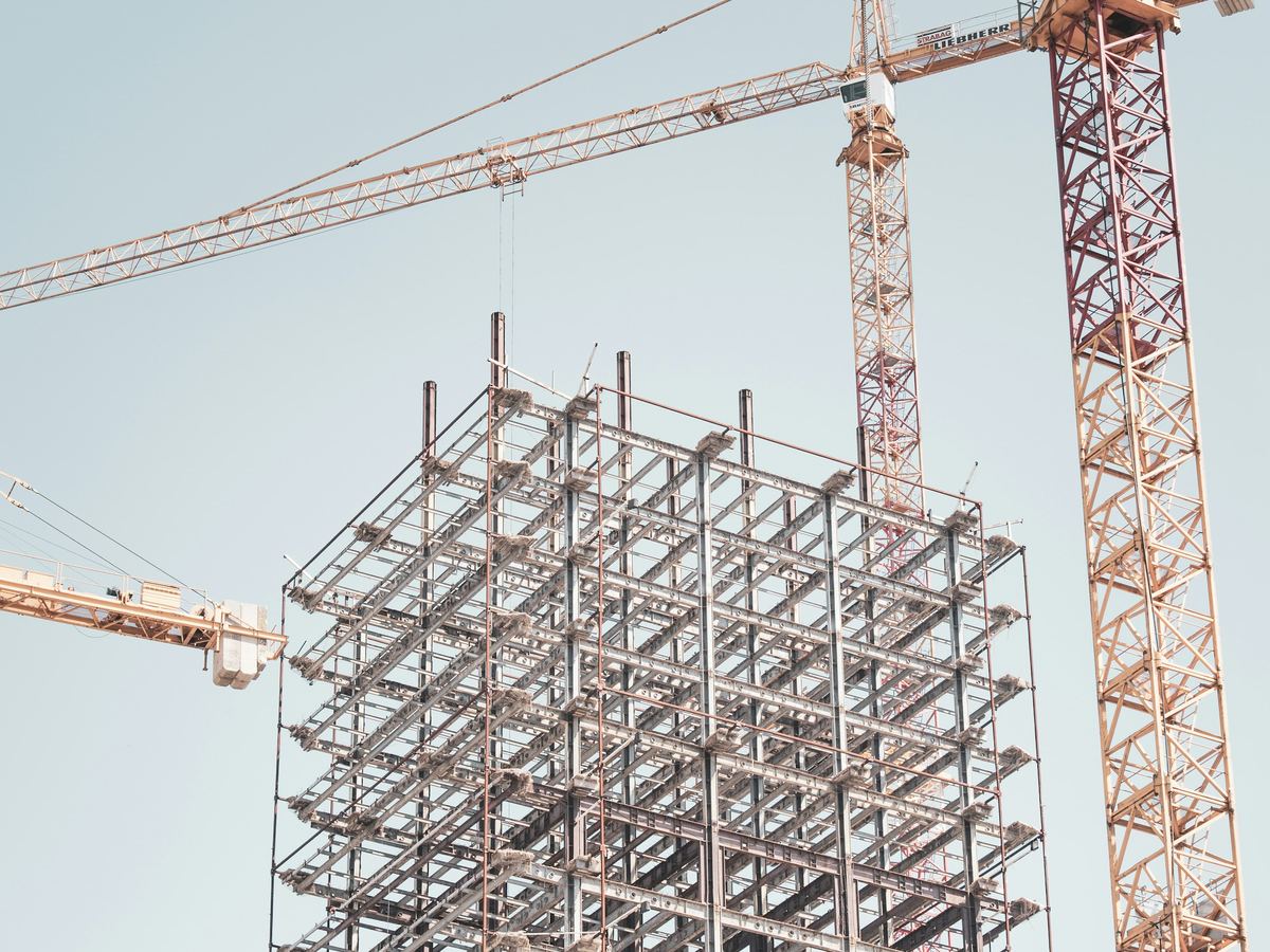 Commercial steel structure beside a tower crane