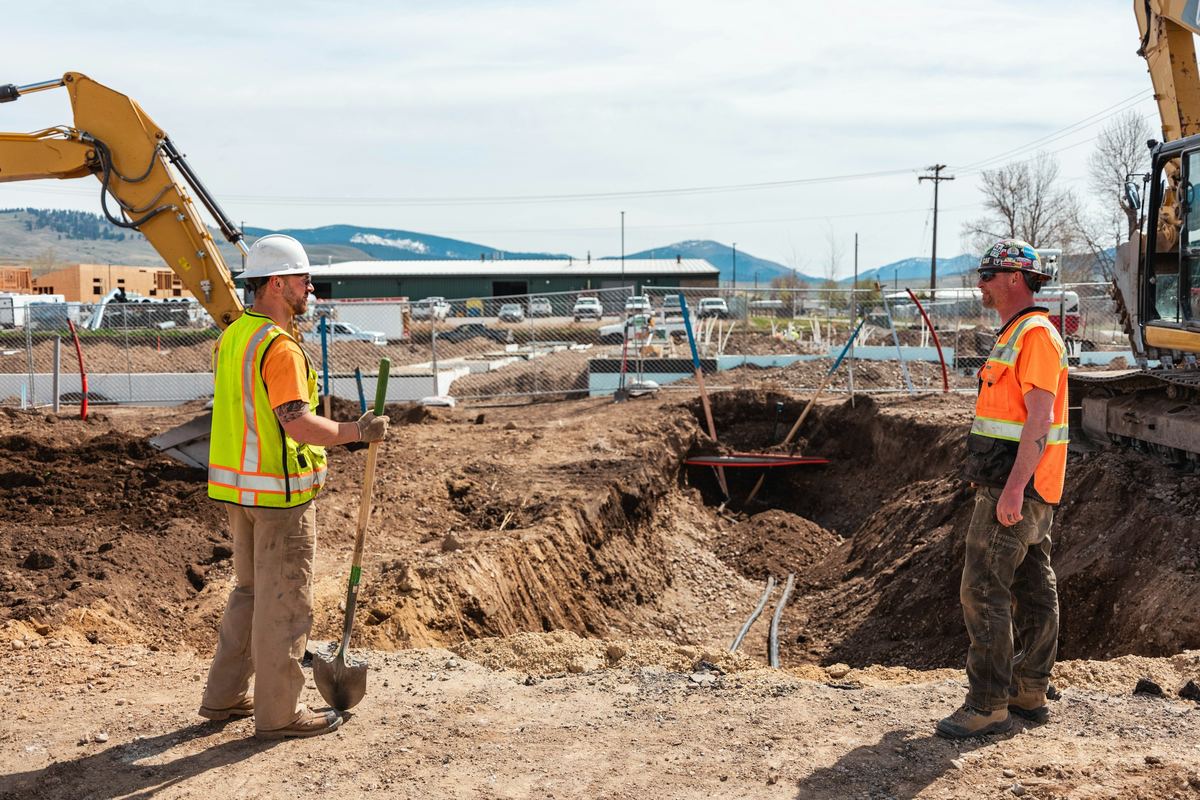 Field personnel coordinating beside an excavation